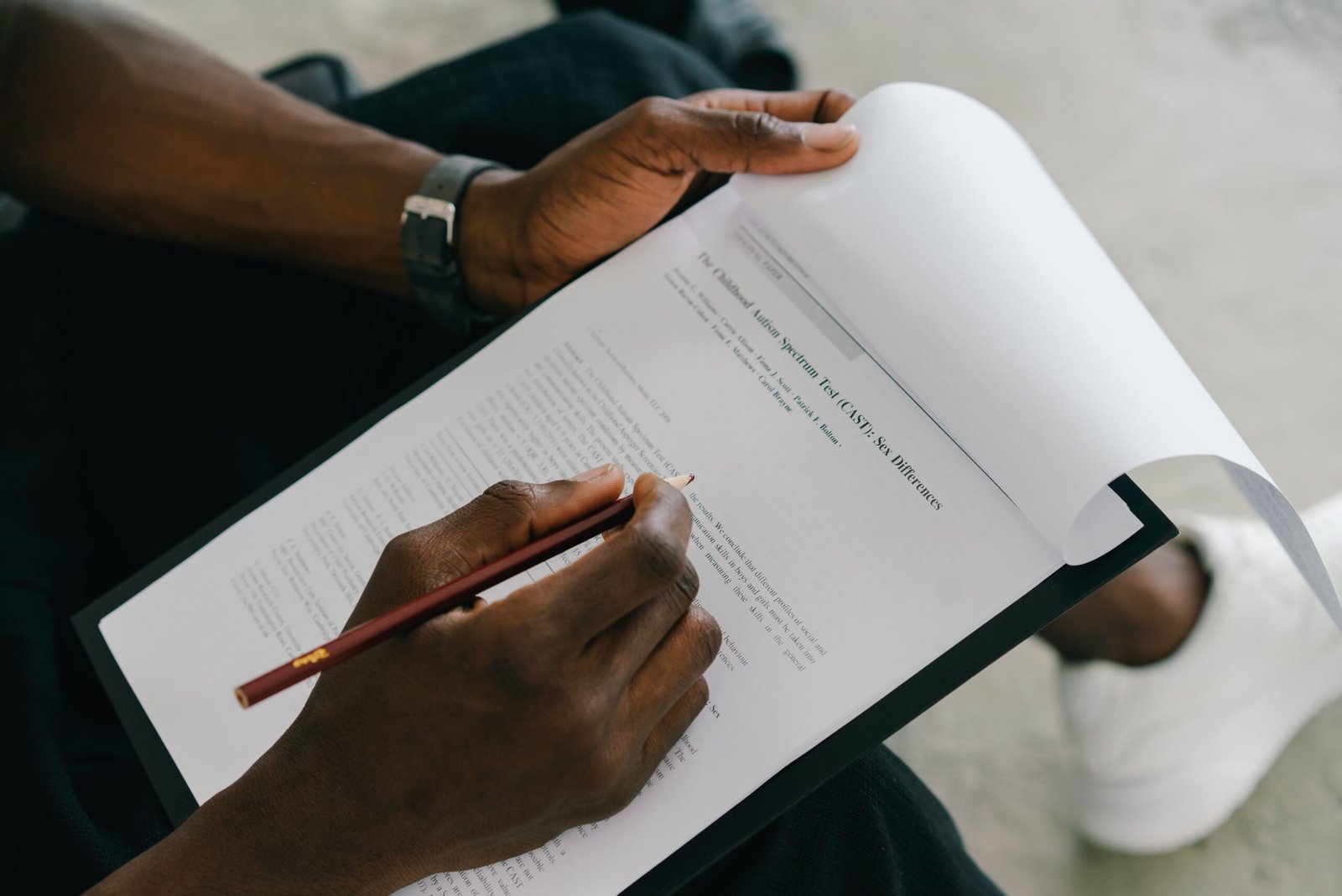 Close-up of a person writing on a psychological assessment form with a pencil.
